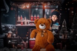 Séance-photo-de-noel-avec-un-enfant-et-un-ours-en-peluche-dans-un-décor-de-studio